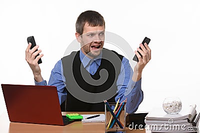 Man with two phones in shock looks at them Stock Photo