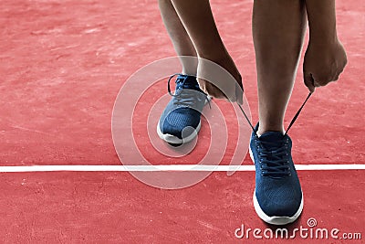 Man tying running shoes on racing track Stock Photo