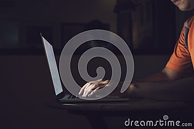 Man typing on keyboard and working at computer laptop in night Stock Photo