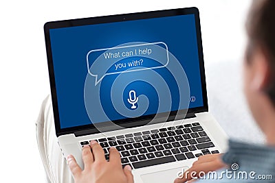 Man typing laptop keyboard with app personal assistant on screen Stock Photo