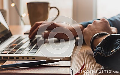 Man typing on laptop with pencil, coffee mug and notepad Stock Photo