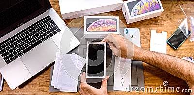 Man unboxing iPhone Xs Max Xr admiring the screen Editorial Stock Photo