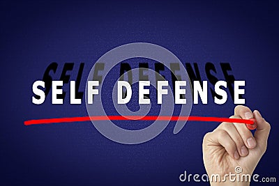 Man underlining words Self Defense with marker glass board against blue background, closeup Stock Photo