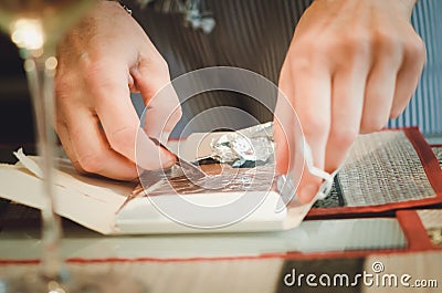 A man unfolds a chocolate, hands. Stock Photo