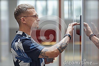 Man Unlocking Office Room with Access Code Indoors Using Smart Wireless Control Panel Stock Photo