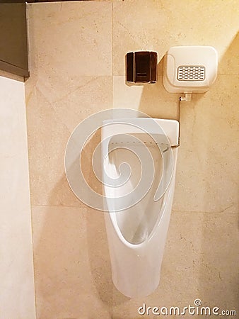 Man urinal install wall for men in toilet Luxury white ceramic flush toilet modern technology in restroom. clean marble floor in r Stock Photo