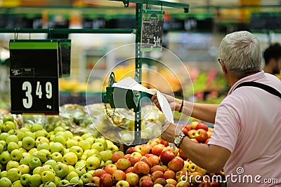 A man uses biodegradable plastic food bags to buy fruits and vegetables from the supermarket Editorial Stock Photo