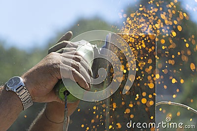 Man uses flexible that makes sparks without using protective gloves. Lack of use of protection systems Stock Photo