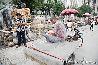 Man uses a mobile while the Panjiayuan Antique Market, Beijing Editorial Stock Photo