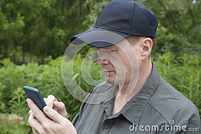 The man uses a smartphone to access the Internet. Using a smartphone Stock Photo