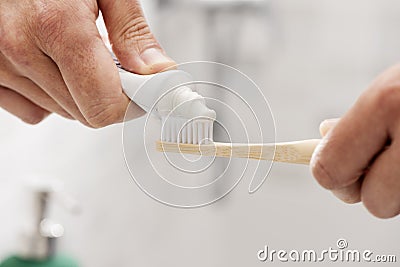 Man using a bamboo toothbrush in the bathroom Stock Photo