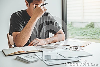 Man using calculator Accounting Calculating Cost Economic bills with money stack step growing growth saving money in home , Stock Photo