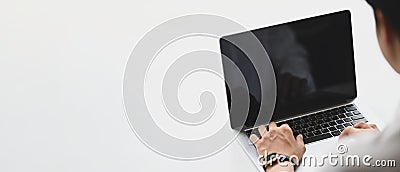 Man is using a computer laptop at the white simple workspace. Stock Photo