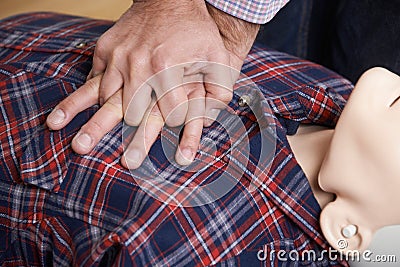 Man Using CPR Technique On Dummy In First Aid Class Stock Photo