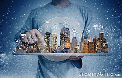 A man using digital tablet with building hologram and internet media icons. Smart city, 5g, internet and networking technology con Stock Photo