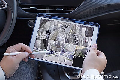 Man using digital tablet with multiple camera views Stock Photo