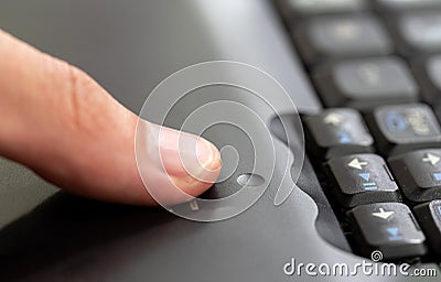 Man using a fingerprint scanner module built into a laptop, finger sliding on the fingerprint sensor detail closeup, one person. Stock Photo