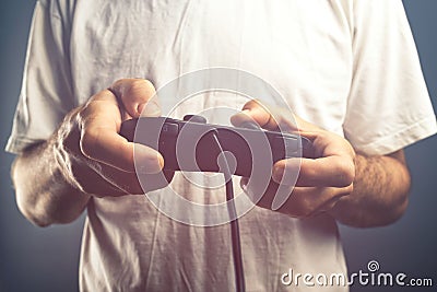 Man using game pad controller to play video games Stock Photo