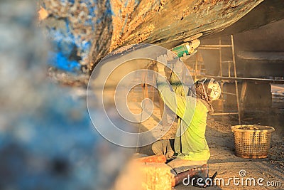 A man using grinder in preparation for anti foul paint being app Stock Photo