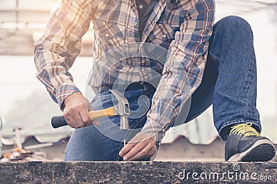 A young man using a hammer to nail concrete. Stock Photo