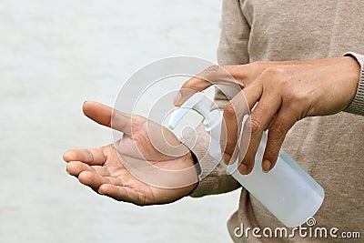 Man using hand press bottle and pouring alcohol-based sanitizer on other hand Stock Photo