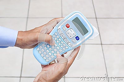 Man using Handheld Label Maker machine Stock Photo