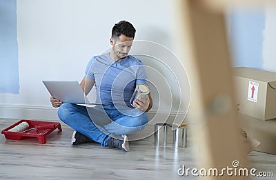 Man using a laptop and choosing a perfect paint Stock Photo