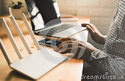 man using mobile with connect wifi on the screen. Man`s hands using device at Home office. Stock Photo