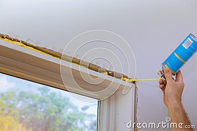 Man in a using a mounting foam window installation Stock Photo