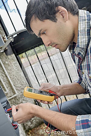 Man using multimeter on exterior electrical box Stock Photo