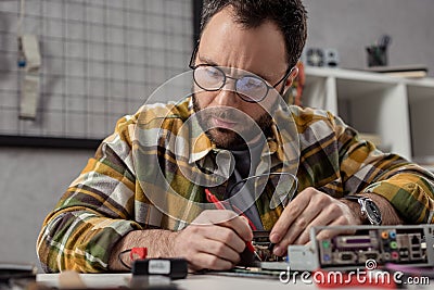 man using multimeter while fixing broken computer Stock Photo