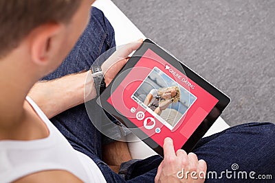 Man using online dating app on tablet Stock Photo