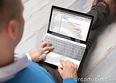 Man using project management software on laptop computer Stock Photo