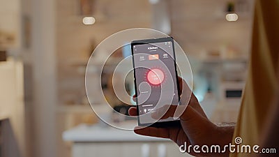 Man using smart home app touching screen to turn on light by phone Stock Photo
