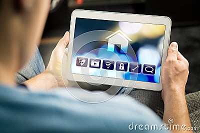 Man using smart home application in tablet to control house Stock Photo