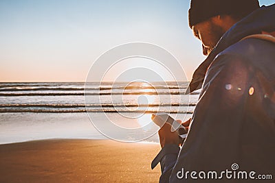 Man using smartphone application online walking on beach modern technology Stock Photo