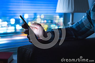 Man using smartphone home at night. Stock Photo