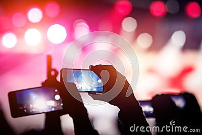 Man using smartphone to take a video at a concert Stock Photo