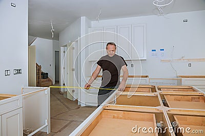 0Man using tape measure for measuring on kitchen in for home improvement Stock Photo