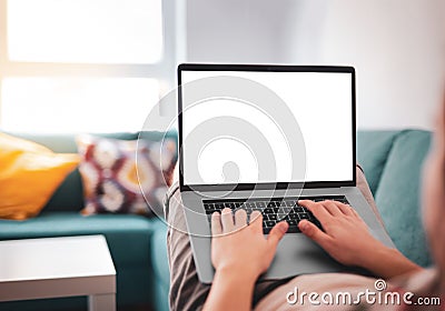 Man using, working on laptop with blank screen while lying on sofa in living room Stock Photo
