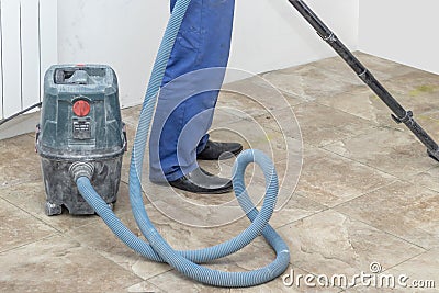 the man vacuums the tile after laying. preparation for jointing Stock Photo