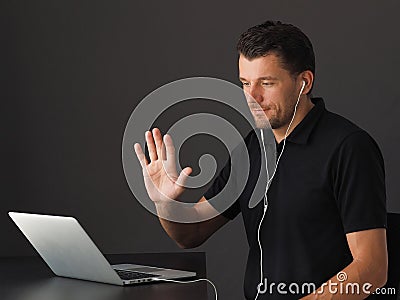 Man in Video conferencing call via laptop and greeting colleagues. Stock Photo