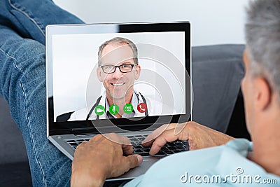 Man Videoconferencing With Doctor On Laptop Stock Photo