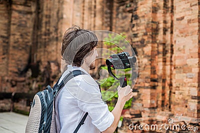 Man videographer shoots video in the electronic stabilizer, steadycam To shoot at Po Nagar Cham Tovers. Digital technology concept Stock Photo