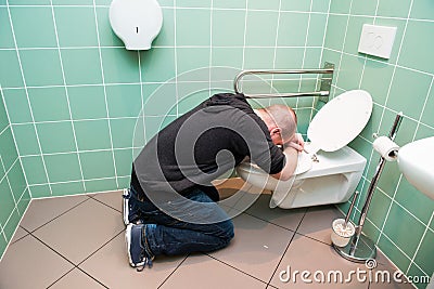 Man vomiting in the toilet Stock Photo
