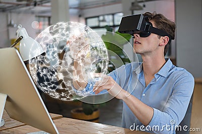 Man in VR headset touching a 3D sphere interface Stock Photo