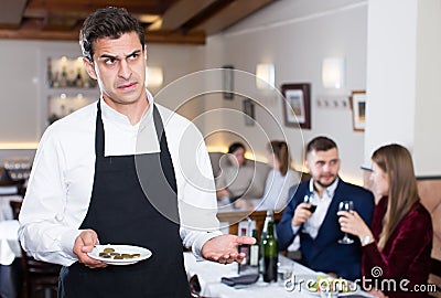 Man waiter dissatisfied with small tip from restaurant visitors Stock Photo