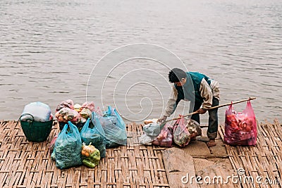 Man Waiting Boat for Moving Commodities in The River at Luang Prabang, Laos Editorial Stock Photo