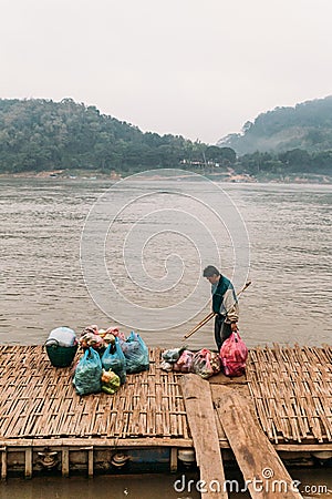 Man Waiting Boat for Moving Commodities in The River at Luang Prabang, Laos Editorial Stock Photo