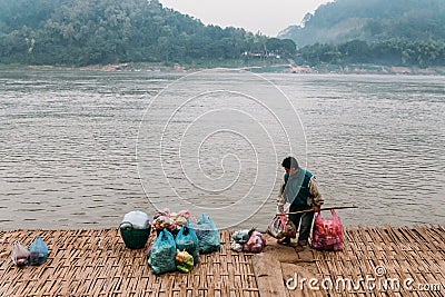 Man Waiting Boat for Moving Commodities in The River at Luang Prabang, Laos Editorial Stock Photo